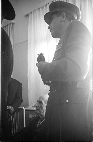 תצלום וינטג 'של ג'ורג'יוס פפנדרו יושב, כאשר האדם במדים עומד לידו.