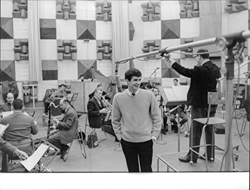תצלום וינטג 'של אנתוני פרקינס עומד מול התזמורת.